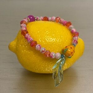 Handmade beaded bracelet. Pink with orange lampwork strawberry.